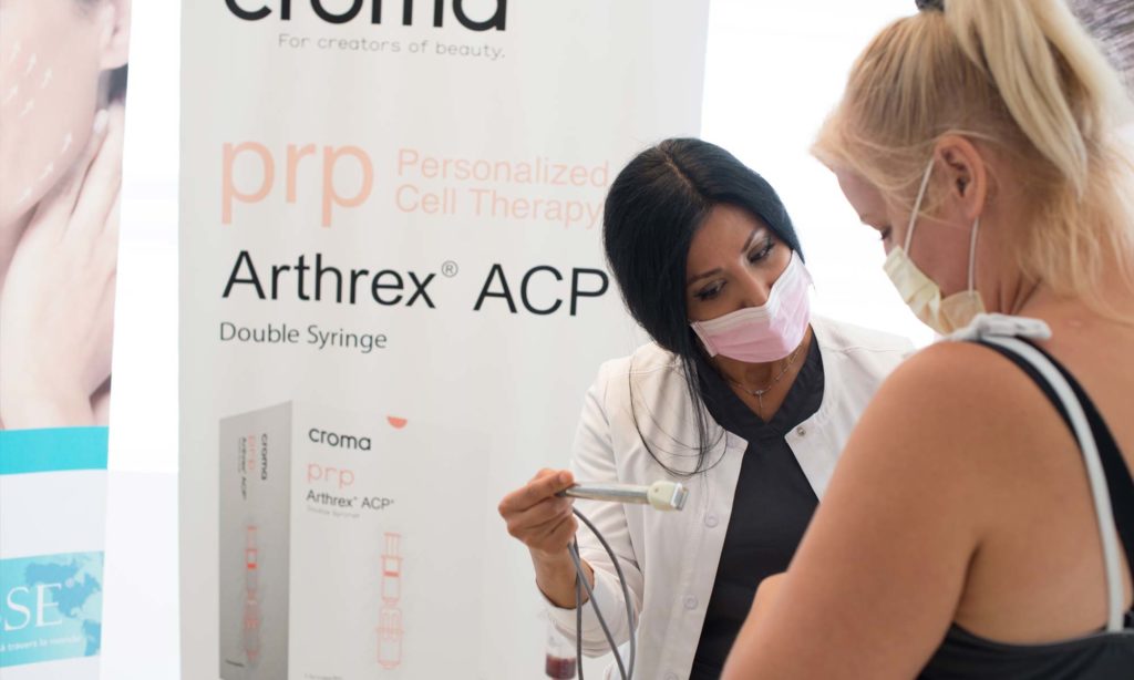 Female techinician with patient performing fractora treatment on female patient