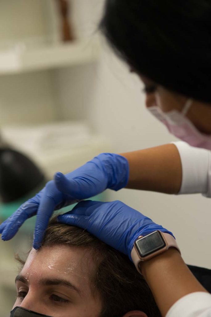 Technicians preparing patient for prp platelet rich plasma vampire facelift