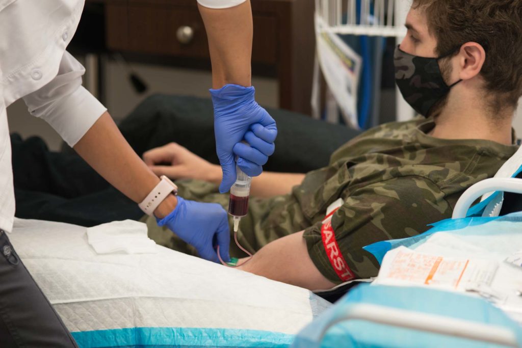 Technician taking blood from patient for prp platelet rich plasma vampire facelift