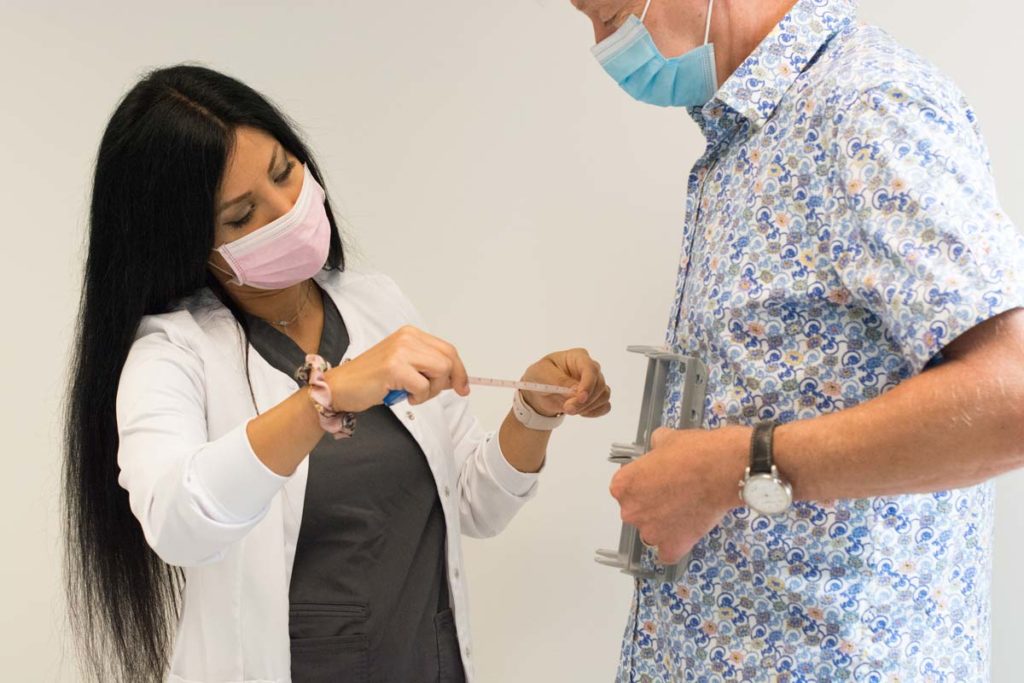 Female technician preparing male patient for sculpsure treatment