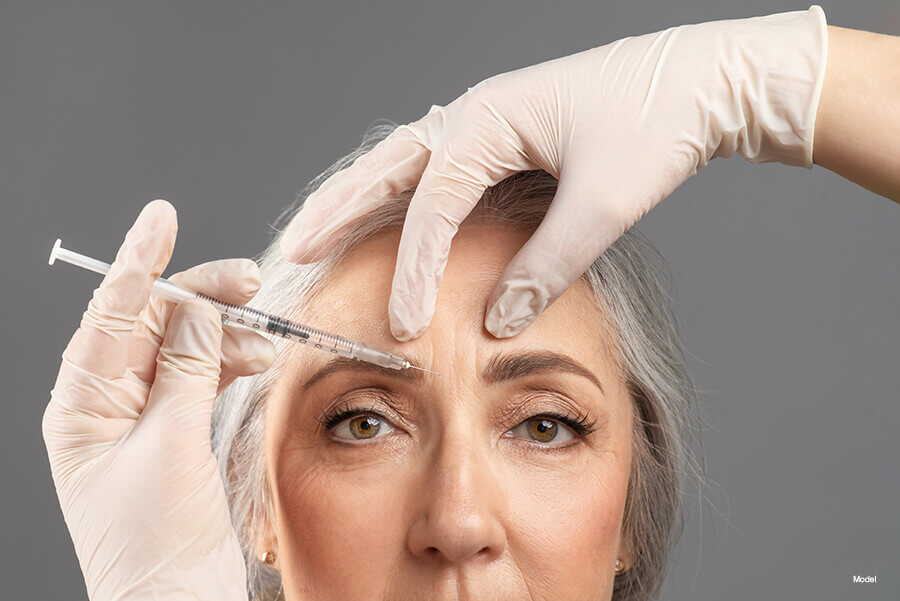 older woman receives injectable in between her brows