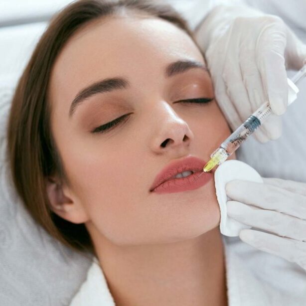 Woman getting dermal filler injection in lip