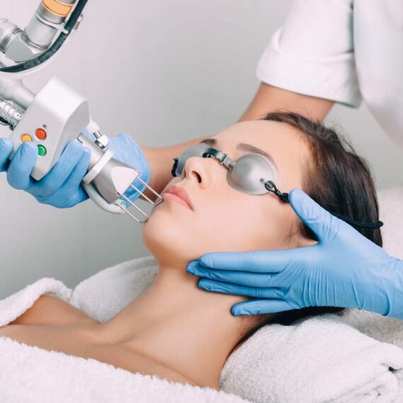 Female patient receiving laser treatment on face